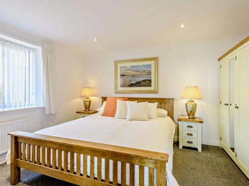 een slaapkamer met een groot bed en 2 lampen bij 1 Bed in Weymouth 57926 in Osmington
