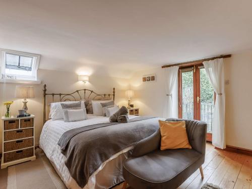 1 dormitorio con 1 cama grande y 1 silla en 3 Bed in Barnstaple 60511 en Swimbridge