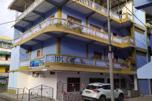 un edificio azul y blanco con un coche aparcado delante en FRIENDS RESIDENCY , Port Blair, en Port Blair