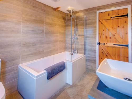 ein Badezimmer mit einer Badewanne und einem Waschbecken in der Unterkunft 2 bed property in Godshill Isle of Wight IC149 in Godshill