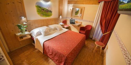 a small hotel room with a bed and a desk at Hotel Baita Montana in Livigno