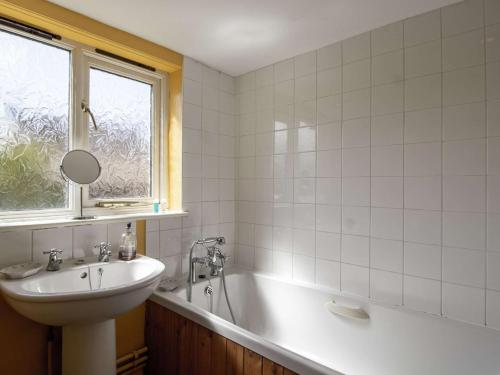 a bathroom with a sink and a tub and a mirror at 2 Bed in Little Walsingham KT093 in Little Walsingham