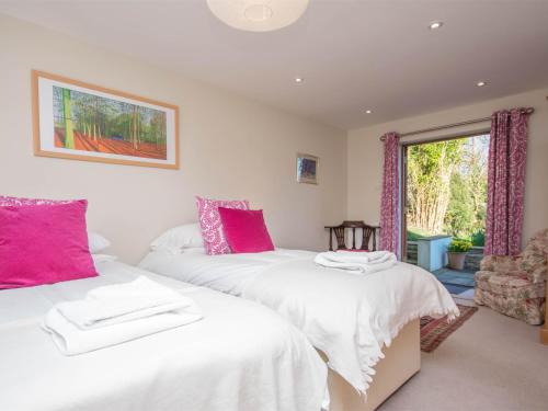2 camas en una habitación con sábanas rosas y blancas en 5 Bed in Corfe Castle DC061, en Corfe Castle