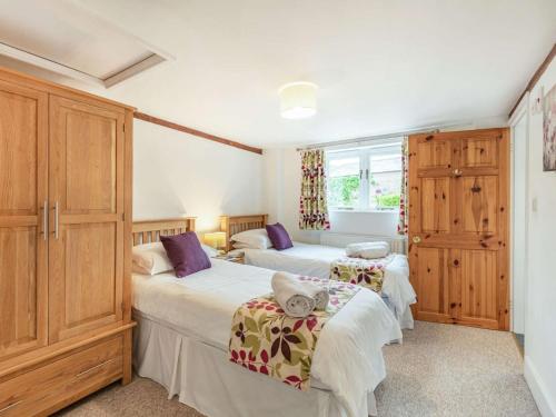 twee bedden in een kamer met houten kasten bij 3 Bed in Wareham DC129 