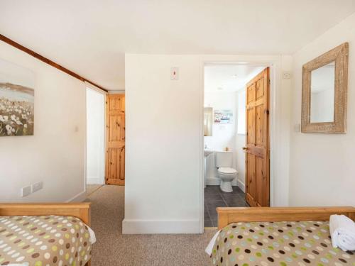 een slaapkamer met 2 bedden en een badkamer bij 3 Bed in Wareham DC129 