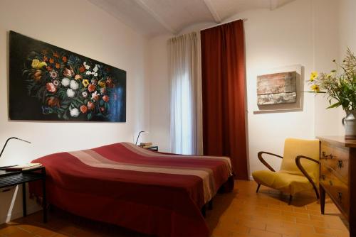 ein Hotelzimmer mit einem Bett und einem Gemälde an der Wand in der Unterkunft Agriturismo Podere il Leccio in Castiglione della Pescaia