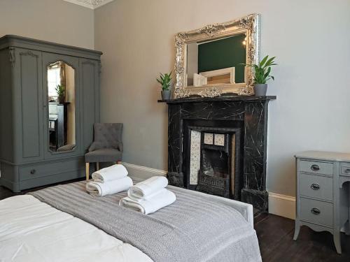 a bedroom with a bed with a fireplace and a mirror at Beautiful Georgian New Town 2 bed apartment in Edinburgh