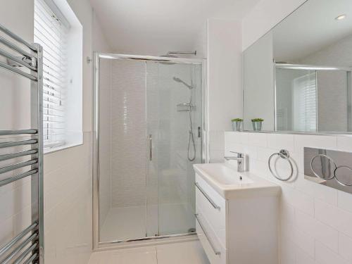 uma casa de banho branca com um chuveiro e um lavatório. em 3 Bed in Westward Ho 74797 em Westward Ho