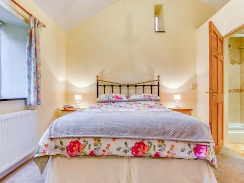 a bedroom with a bed with a floral bedspread at 1 Bed in Padstow 75736 in Saint Ervan