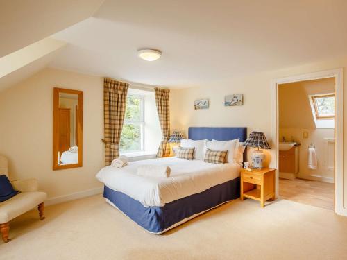 a large bedroom with a large bed and a chair at 6 Bed in Ullapool CA259 in Ullapool
