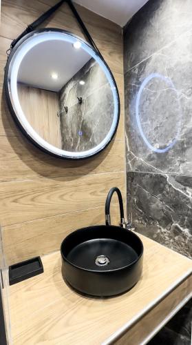 a black sink in a bathroom with a mirror at Theoni Luxury Apartment in Kalavrita