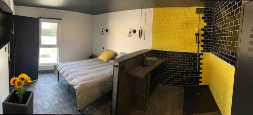 baño con cama y ducha con azulejos amarillos en Les Gîtes Warenne - 2, en Saint-Étienne-au-Mont