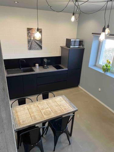 une cuisine avec une table, des chaises et un comptoir dans l'établissement Les Gîtes Warenne - 2, à Saint-Étienne-au-Mont