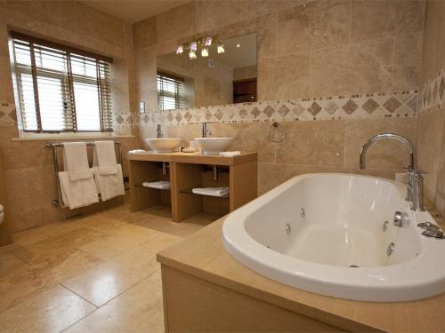 a large bathroom with a tub and two sinks at 4 bed in Hovingham G0146 in Hovingham