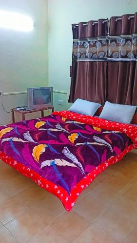 a bed with a colorful comforter in a room at Holiday home in Ooty