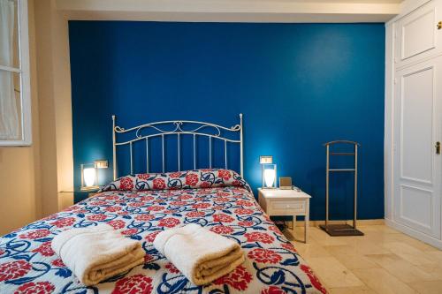 niebieska sypialnia z łóżkiem i dwoma ręcznikami na nim w obiekcie APARTAMENTO EN CASA PALACIO CON PISCINA 15 MAYO a 15 OCTUBRE w Sewilli