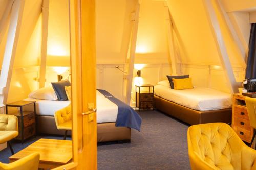 um pequeno quarto com 2 camas e uma cadeira em Hotel de Gulden Leeuw em Workum