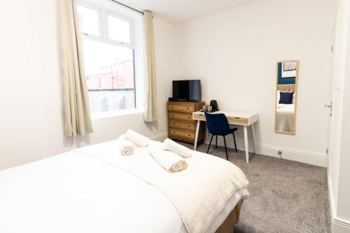 Suite 2 - Comfy Spot in Oldham Sociable House في أولدهام: غرفة نوم بسرير ومكتب ونافذة
