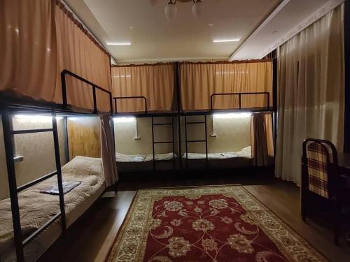 a room with two bunk beds and a rug at Archa Hostel in Bishkek