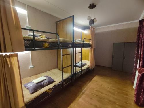 a room with two bunk beds in a room at Archa Hostel in Bishkek