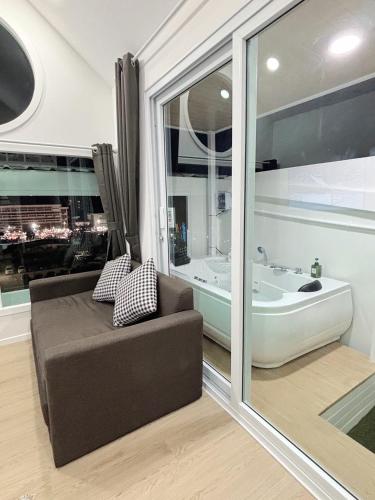 a living room with a couch and a bath tub at Sugar Beach Bangsaen in Ban Bang Saen (1)