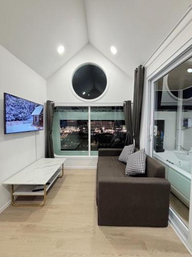 a living room with a couch and a large window at Sugar Beach Bangsaen in Ban Bang Saen (1)