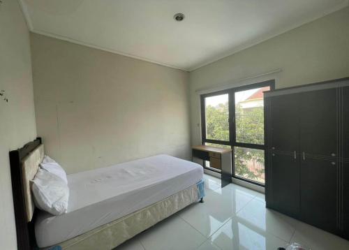 ein Schlafzimmer mit einem Bett und einem großen Fenster in der Unterkunft OYO 93500 Rizki Residence TOS Syariah in Jakarta
