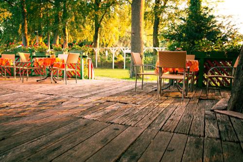 a group of chairs and tables on a wooden deck at Landgasthof & Hotel Jagdhof in Stralsund