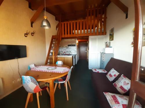 Cette petite chambre comprend une table et un canapé. dans l'établissement Studio mezzanine vue montagne, à Font-Romeu-Odeillo-Via