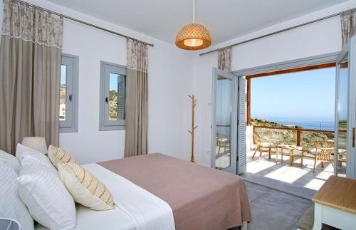 een slaapkamer met een bed en uitzicht op de oceaan bij Villa Avgi in Agios Nikolaos