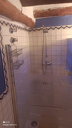 a bathroom with a shower with white tiles at L'Antic Forn de Paüls in Paúls