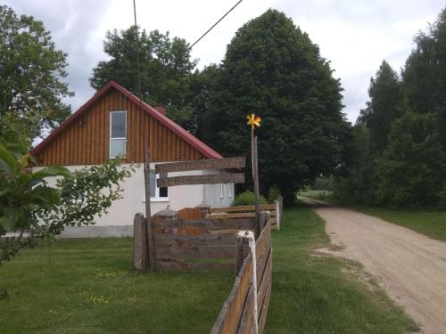 a church with a wooden fence and a cross on a pole at Agroturystyka na Łubii in Miastkowo