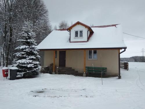 een klein huis met een met sneeuw bedekt dak bij Agroturystyka na Łubii in Miastkowo