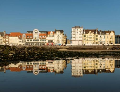 une ville avec des bâtiments et des reflets dans l'eau dans l'établissement Studio lumineux - Conciergerie Leroy, à Wimereux