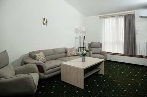 ein Wohnzimmer mit einem Sofa und einem Couchtisch in der Unterkunft Colette Hotel in Yerevan