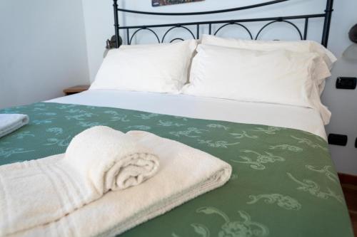 a bed with a green and white blanket on it at Agriturismo Il Giardino Degli Ulivi in Lazise