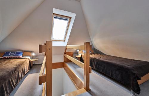 een zolderkamer met 2 bedden en een raam bij Scharhörn - 7 in Cuxhaven