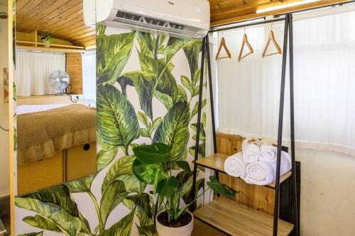 a bedroom with a mural of plants on the wall at MashikaBus משיקה בס אירוח מפנק על גלגלים in Ta‘oz