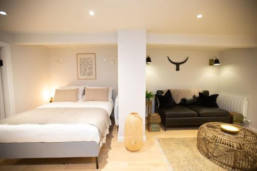 a bedroom with two beds and a couch at Chorlton Stylish Studio & Roof Terrace Apartments in Manchester
