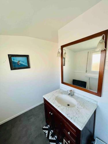 une salle de bain avec un lavabo et un miroir dans l'établissement La Maison du Temps Retrouvé à Wissant, à Wissant