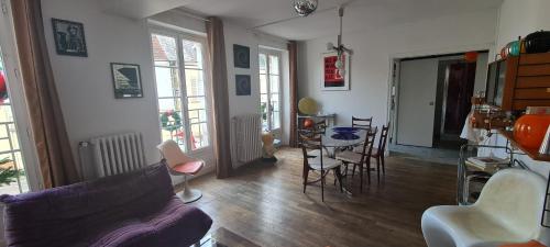 un salon avec un canapé, une table et des chaises dans l'établissement Appart 70s au cœur du Perche, à Rémalard