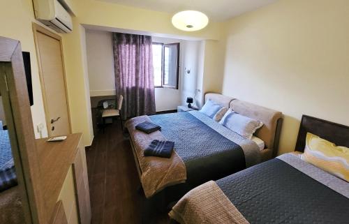 ein Hotelzimmer mit 2 Betten und einem Fenster in der Unterkunft Spacious and Cozy Apartment in Tirana