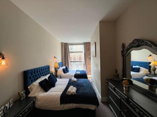 a bedroom with two beds and a large mirror at Cornwallis 1 bedroomed 2 beds- sleeps 5- FREE Parking in Liverpool