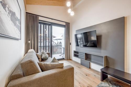 a living room with a couch and a television at Summit Seefeld in Seefeld in Tirol