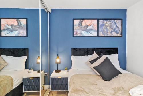 two beds in a room with blue walls at Harbourside Heaven in Bristol - Sleeps 8 in Bristol