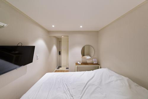 1 dormitorio con 1 cama y TV de pantalla plana en Life In Insa, en Seúl