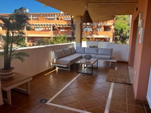 a patio with a couch and a table on a balcony at Center beach 2 beds Appartement Elviria in Marbella
