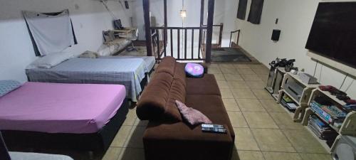 a living room with two beds and a couch at Casa da árvore na praia in São Sebastião