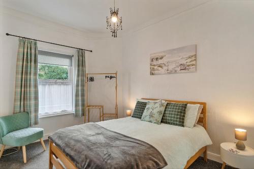 a bedroom with a bed and a chair and a window at Finest Retreats - Atherfield Apartments No 6 - Tree Tops in Paignton