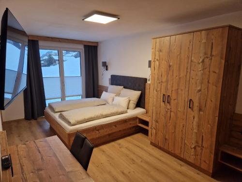 um quarto com uma cama e um armário de madeira em Gern Mountain Living Ferienhaus Deutschmann em Sankt Johann im Pongau